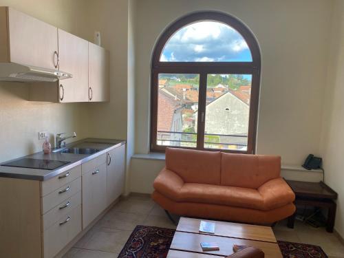 a kitchen with a couch and a large window at Auberge de Gilly SA in Gilly