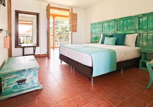 1 dormitorio con 1 cama grande y espejo en Zenith Bed & Breakfast, en Pereira