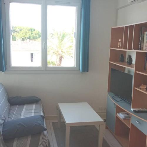 een kamer met een bureau, een tafel en een raam bij Petit repaire relaxant in Saint-Cyr-sur-Mer