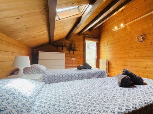 twee bedden in een kamer met houten wanden bij Villa Lotus by Costabravaway in Calonge