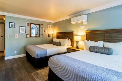 a hotel room with two beds and a mirror at Cambria Pines Lodge in Cambria