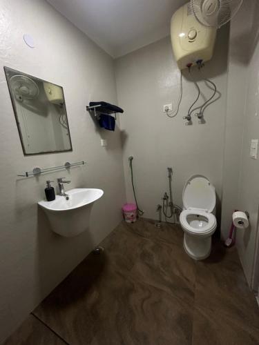 Home Away Home ( East Of Kailash ) New Delhi في نيودلهي: حمام مع حوض ومرحاض ومرآة