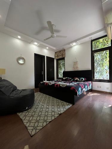 Home Away Home ( East Of Kailash ) New Delhi في نيودلهي: غرفة نوم بسرير واريكة