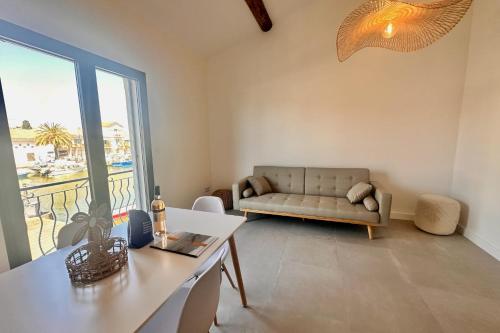 un salon avec un canapé et une table dans l'établissement Les Palmiers - Appartement une chambre vue canal, au Grau-du-Roi