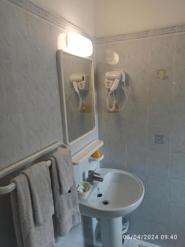 a bathroom with a sink and a mirror and towels at Hotel Armida in Laigueglia