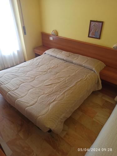 a bed in a bedroom with a wooden headboard at Hotel Armida in Laigueglia