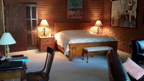 a bedroom with a bed and a table and chairs at Desert Trails Bed & Breakfast in Tucson