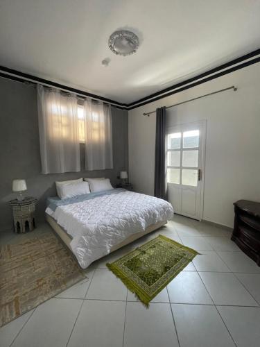 um quarto com uma cama branca e uma janela em Banana Surf House em Tamri