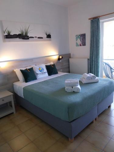 una camera da letto con un letto grande con asciugamani sopra di Villa Chariklia Studios a Kambiá