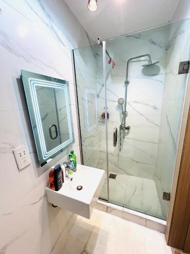 baño blanco con ducha y lavamanos en Luxury Studio Apartment (with PS5) in Lekki phase1, en Moba
