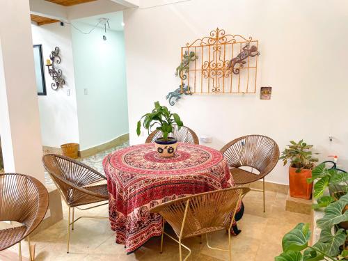 a dining room with a table with chairs and a plant at Casa Victoria in Montería