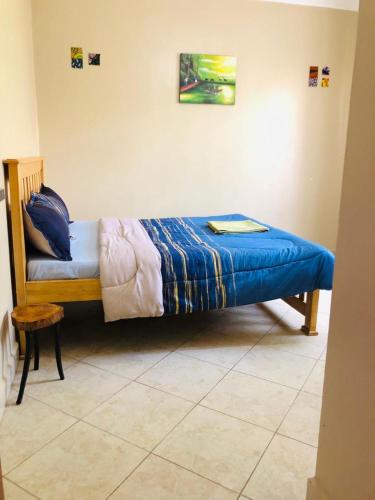 a bed with a blue comforter in a room at Maritah Homes in Kampala