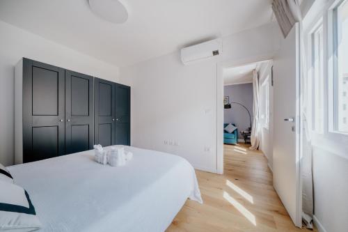 1 dormitorio blanco con 1 cama con 2 toallas en Elegante appartamento in Marina en Trieste