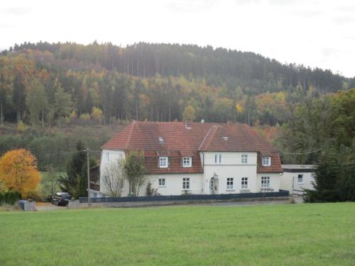 ein weißes Haus mit rotem Dach auf einem Feld in der Unterkunft Ferienwohnung für sechs Personen - b56987 in Medebach