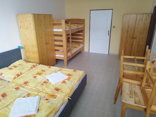 a room with a bed and two bunk beds at Penzion U Lipna in Přední Výtoň