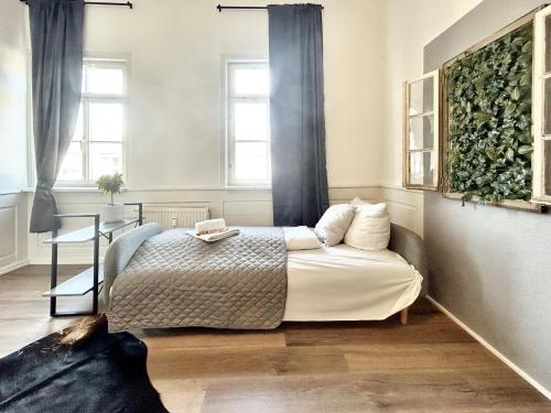 um quarto com uma cama, uma mesa e janelas em BackHome - Fantastische Schlosslage, SmartTV, Netflix, 70qm, 24h Checkin - Apartment 2 em Ludwigsburg