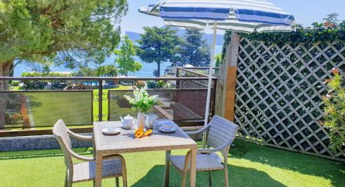 een tafel en stoelen met een parasol op een patio bij Mini-Penthouse Attico Bianca in San Felice del Benaco
