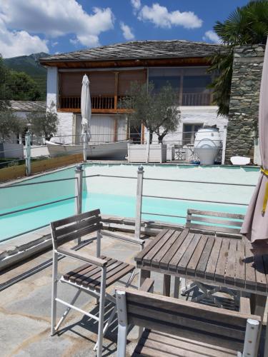 a swimming pool with a bench and an umbrella at Villa Domatia in Kavala