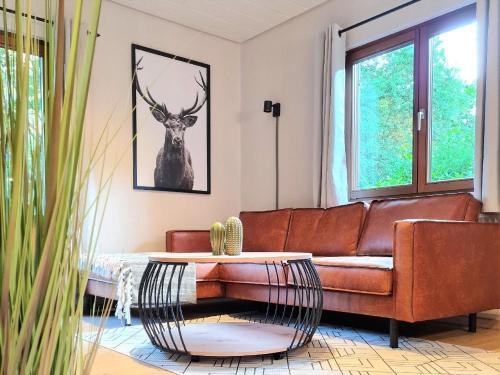 a living room with a brown couch and a deer picture at Tolles Ferienhaus in Kirchheim mit Schönem Garten in Kirchheim