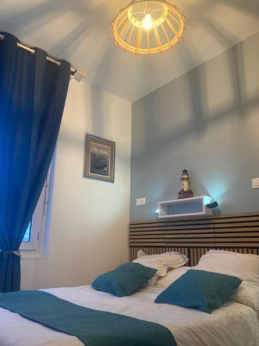 1 dormitorio con 2 camas y lámpara de araña en Les chambres du Phare, en Port-des-Barques