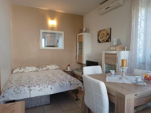 una camera con letto, scrivania e tavolo di Apartment Luka a Fažana