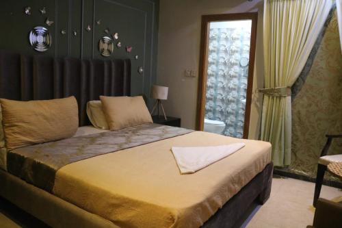 Un dormitorio con una cama grande y una ventana en Sabs Residences, en Islamabad