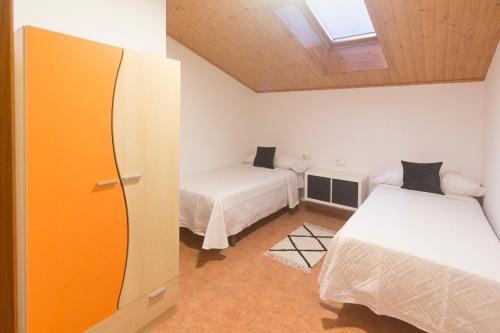 een kleine kamer met twee bedden en een raam bij casa picota in Oia