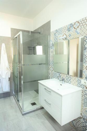 a bathroom with a white sink and a shower at Casa Vacanze Altea in Santa Flavia