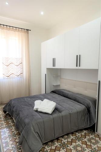 a bedroom with a large bed with white cabinets at Casa Vacanze Altea in Santa Flavia
