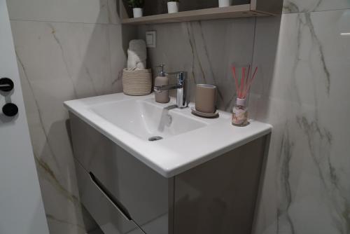 a bathroom with a white sink in a room at Diamond 72 apartment , Skopje City - Center, Diamond Residences, free parking in Skopje