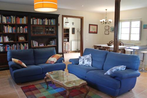 una sala de estar con 2 sofás azules y una mesa. en Casa de Aldea Monga 9 en Nava, Asturias, en Nava