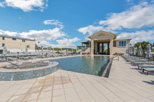 uma piscina com cadeiras e um edifício em Fully loadedPrivate Beachsleeps10 withGolf! home em Gulf Highlands