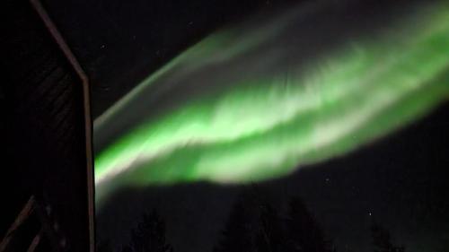 uma imagem das luzes do norte no céu em Villa Assar, Ferienhaus in der Nähe von Schwedens größten Stromschnellen em Vidsel