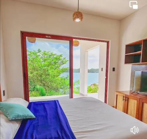 1 dormitorio con cama y ventana grande en Estancia del Agua Luxury View, en Xul-Ha
