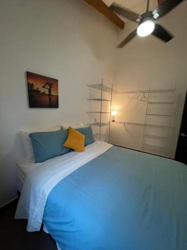 1 dormitorio con 1 cama grande con almohadas azules en TRANQUILA CASA DE PLAYA, en Santa Cruz