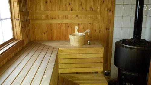 uma sauna com um balde num piso de madeira em Geräumiges Ferienhaus mit Außensauna, in der Nähe vom Storforsen, Schwedens größten Stromschnellen em Vidsel