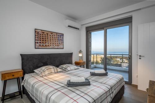 a bedroom with a bed and a large window at Kokinogremos Villa in Kalithies