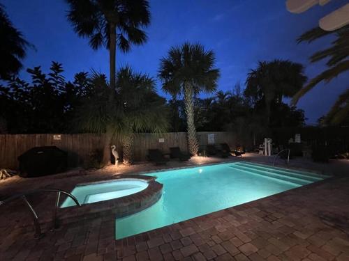 une piscine dans une cour la nuit dans l'établissement Seaside Retreat Cottages #3, à Clearwater Beach
