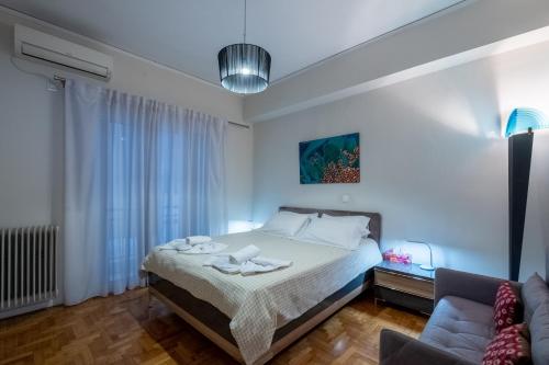 ein Schlafzimmer mit einem Bett und einem Sofa in der Unterkunft Oro's Stylish Kolonaki Flats Next to Metro & Museums in Athen