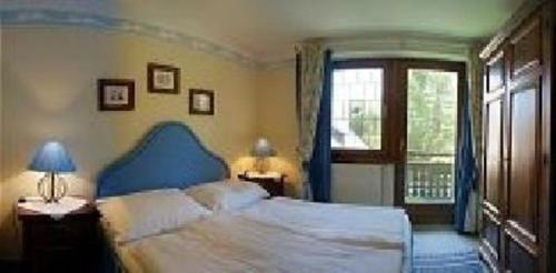 1 dormitorio con 1 cama con cabecero azul y ventana en Wohnung mit Balkon und toller Aussicht en Falkertsee