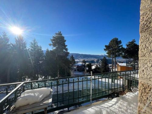 a snow covered bench on a balcony with the sun shining at 2 pièces 30m2 et Balcon vue montagne Villa Saint Paul WIFI Location à la semaine du samedi au samedi in Font Romeu Odeillo Via