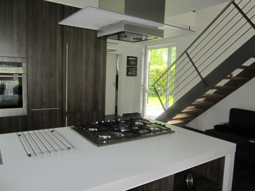 eine Küche mit einem Herd oberer Ofen neben einer Treppe in der Unterkunft Ferienhaus für 4 Personen ca 165 m in Mardorf, Norddeutschland Niedersachsen in Neustadt am Rübenberge