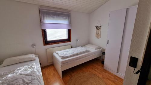 a small bedroom with two beds and a window at Ferienhaus Namenlos in Butjadingen