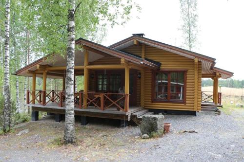 uma cabana de madeira na floresta com uma árvore em Ferienhaus für 8 Personen 2 Kinder ca 100 qm in Myllykylä, Kanta-Häme em Myllykylä