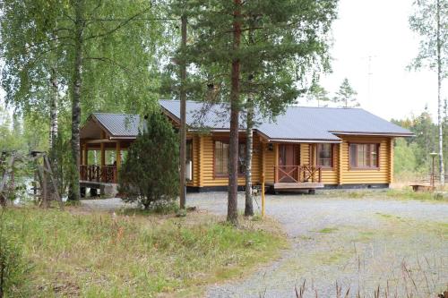 uma cabana de madeira na floresta com um quintal em Ferienhaus für 8 Personen 2 Kinder ca 100 qm in Myllykylä, Kanta-Häme em Myllykylä