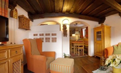 a living room with orange chairs and a table at Ferienhaus in Reichenau mit Grill und Terrasse und Panoramablick in Falkertsee