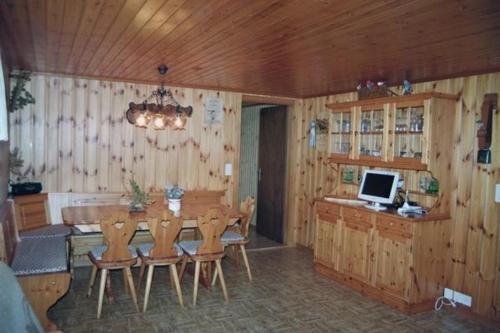 a dining room with a table with chairs and a computer at Fruehalp - b48505 in Unterägeri