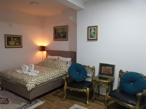 sypialnia z łóżkiem i 2 krzesłami w obiekcie In Apartments AirPort w mieście Mitrovići