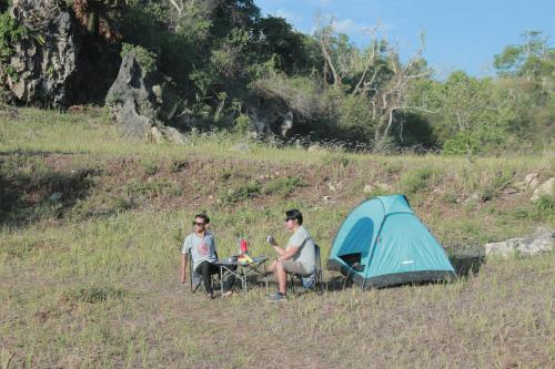 Ngandong的住宿－Wisata Alam Lestari Gunung Semar，两人坐在帐篷旁边的桌子上