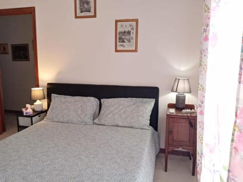 1 dormitorio con 1 cama y 1 mesa con lámpara en Daro's apartment, en Selargius